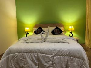 a bedroom with a bed with two swans on it at DIAMOND Hotel and Resort in Dargai