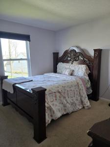 - une chambre avec un lit avec un cadre en bois et une fenêtre dans l'établissement Your Home Away from Home, à Marysville