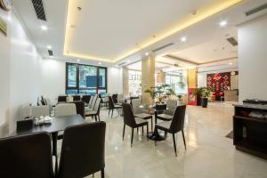 a restaurant with tables and chairs in a room at A25 Hotel - Hoàng Đạo Thúy 2 in Hanoi