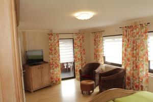 ein Wohnzimmer mit einem TV und einem Stuhl in der Unterkunft Ferienwohnung Erika in Wimbach