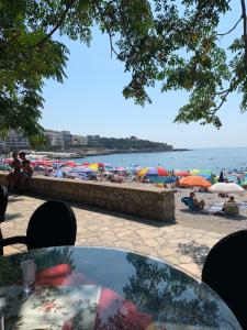 a beach with umbrellas and people sitting on the beach at VILA Ena in Dobra Voda