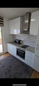 a kitchen with white cabinets and a stove top oven at VILA Ena in Dobra Voda