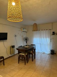a dining room with a table and a television at Dpto Costanera Gualeguaychu Alem in Gualeguaychú