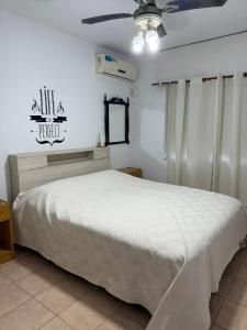 a bedroom with a white bed and a ceiling fan at Dpto Costanera Gualeguaychu Alem in Gualeguaychú