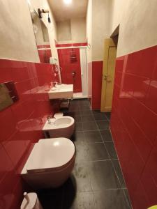 a red bathroom with a toilet and a sink at fairytale home - la corte in Agropoli +27 photos