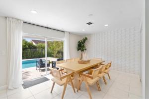 a dining room with a table and chairs and a pool at 6BR 3BA Heated Pool Miami Vacation in Miami