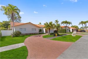a house with palm trees and a driveway at 6BR 3BA Heated Pool Miami Vacation in Miami