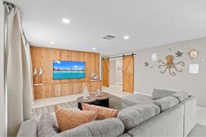 a living room with a couch and a tv at 6BR 3BA Heated Pool Miami Vacation in Miami