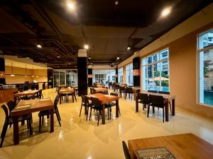 a restaurant with wooden tables and chairs and windows at Crown Pattaya Beach Hotel in Pattaya