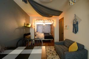 a living room with a couch and a bedroom at Obbligato in Sapporo