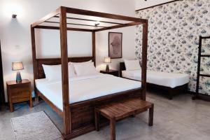 a bedroom with two canopy beds and two tables at The 6th Milepost Tea Bungalow Bandarawela in Bandarawela