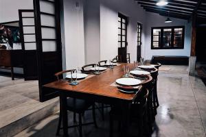 a long wooden table with chairs and plates on it at The 6th Milepost Tea Bungalow Bandarawela in Bandarawela +17 photos