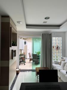 a living room with a white couch and a table at Charmosa Casa em bairro nobre de Curitiba in Curitiba