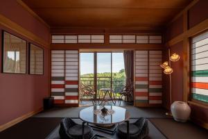 a room with a table and chairs and a window at Maigre YEBISU in Ito