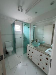 a bathroom with a sink and a shower and a toilet at Charmosa Casa em bairro nobre de Curitiba in Curitiba +28 photos