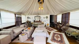 a living room with white furniture and a tent at Star Wars luxury camp in Wadi Rum