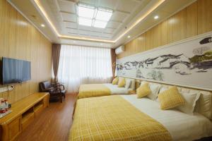 a hotel room with two beds and a flat screen tv at Floral Yilanxuan Zhouzhuang Hotel in Suzhou