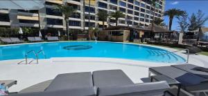 a large swimming pool in front of a building at Doñana Beachfront y acceso directo a la playa de Patalavaca in Patalavaca +51 photos