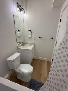 a white bathroom with a toilet and a sink at Amazing 2-bedroom house with WiFi in Edmonton in Edmonton