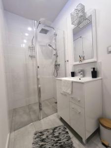 a white bathroom with a shower and a sink at Neo Retro in Jelenia Góra +14 photos