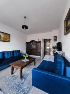 a living room with a blue couch and a table at Neo Retro in Jelenia Góra
