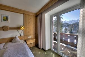 a bedroom with a bed and a large window at Hotel Rezia in La Villa +37 photos