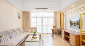 een woonkamer met een witte bank en een tafel bij Fu'an Tailong Sea-view Hotel (Danzhou Haihua Island) in Dongshan