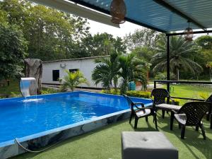 una piscina en un patio con sillas y mesa en Montaña Serena, en Doradal