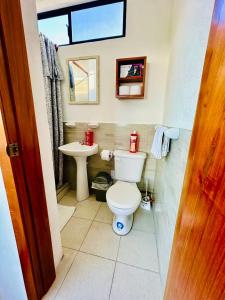 Un baño pequeño con inodoro y lavabo. en CASA FAMILIAR con vista BAHIA Y TERRAZA, en Puerto Ayora