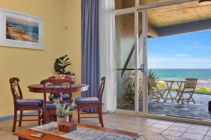 a living room with a table and a view of the ocean at Beachfront Bliss for Two l Nova Escapes in The Entrance