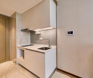 eine Küche mit weißen Schränken und einer Spüle in der Unterkunft Yifang Apartment in Hangzhou