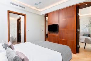 a bedroom with a bed and a tv and a cabinet at Best Western Hotel Nazionale in Sanremo