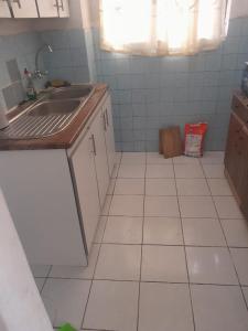 a kitchen with a sink and a tiled floor at Overport Two Bedroom Apartment in Durban
