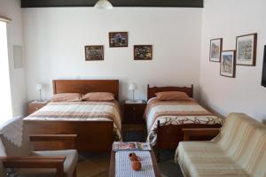 a bedroom with two twin beds and a couch at I Plateia in Kalopanayiotis