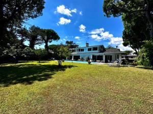 a house with a large yard in front of it at La Grande Villa with Pool in Lignano Sabbiadoro