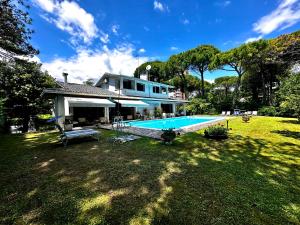 a house with a swimming pool in a yard at La Grande Villa with Pool in Lignano Sabbiadoro