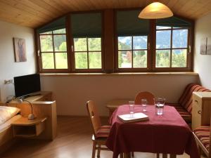 a room with a table and chairs and windows at Appartement Dertnig in Wagrain
