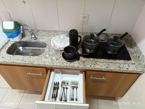 Una encimera de cocina con una estufa y un fregadero. en Serra Park Reservas, en Rio Quente