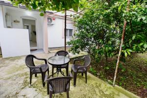 a patio with four chairs and a table and a tree at Sweet Hilltop Escape in Zelenika