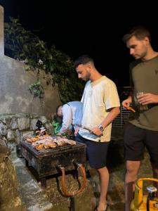 a group of men standing around a grill at Avons Residence Hanthana in Kandy