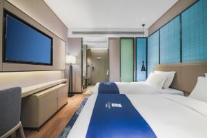 Un dormitorio con dos camas y un televisor de pantalla plana. en Echarm Hotel Changsha Wuyi Square Railway Metro Station, en Changsha 258 fotos más