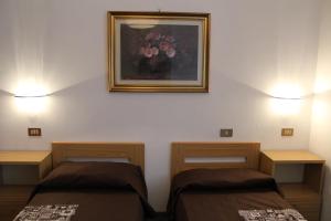 Cette chambre comprend 2 lits et une photo murale. dans l'établissement In centro a Saint Vincent, à Saint-Vincent