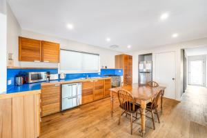 a kitchen with wooden cabinets and a wooden table at Chinamans at Hyams Beach in Hyams Beach