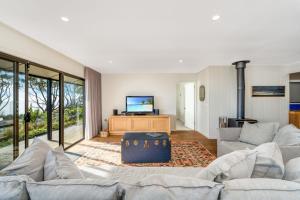 a living room with a couch and a tv at Chinamans at Hyams Beach in Hyams Beach