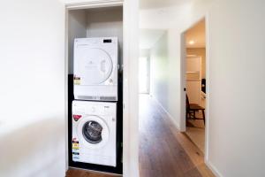 a laundry room with a washer and dryer at Chinamans at Hyams Beach in Hyams Beach +16 photos