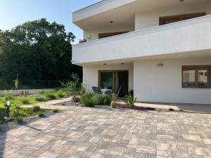 a white house with a patio in front of it at Apartment Oblica-beautiful new, well equipped apartment in Kastav