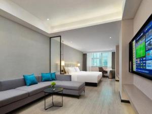 a hotel room with a couch and a bed and a television at Borrman Hotel Golden Crown Liuzhou Wuxing Pedestrian Street in Liuzhou +249 photos