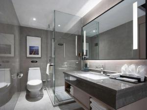 une salle de bain avec un lavabo, des toilettes et un miroir dans l'établissement Borrman Hotel Golden Crown Liuzhou Wuxing Pedestrian Street, à Liuzhou 265 autres photos