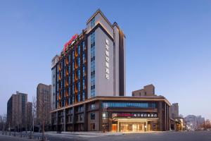 Un edificio alto con un cartel encima. en 北京传媒大学希尔顿欢朋酒店Hampton by Hilton Beijing Communication University, en Beijing