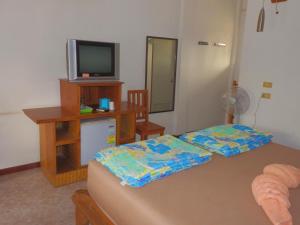 Sala de estar con 2 camas y TV en MG Guesthouse, en Sukhothai